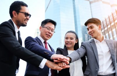 Group of business people stand congratulated.