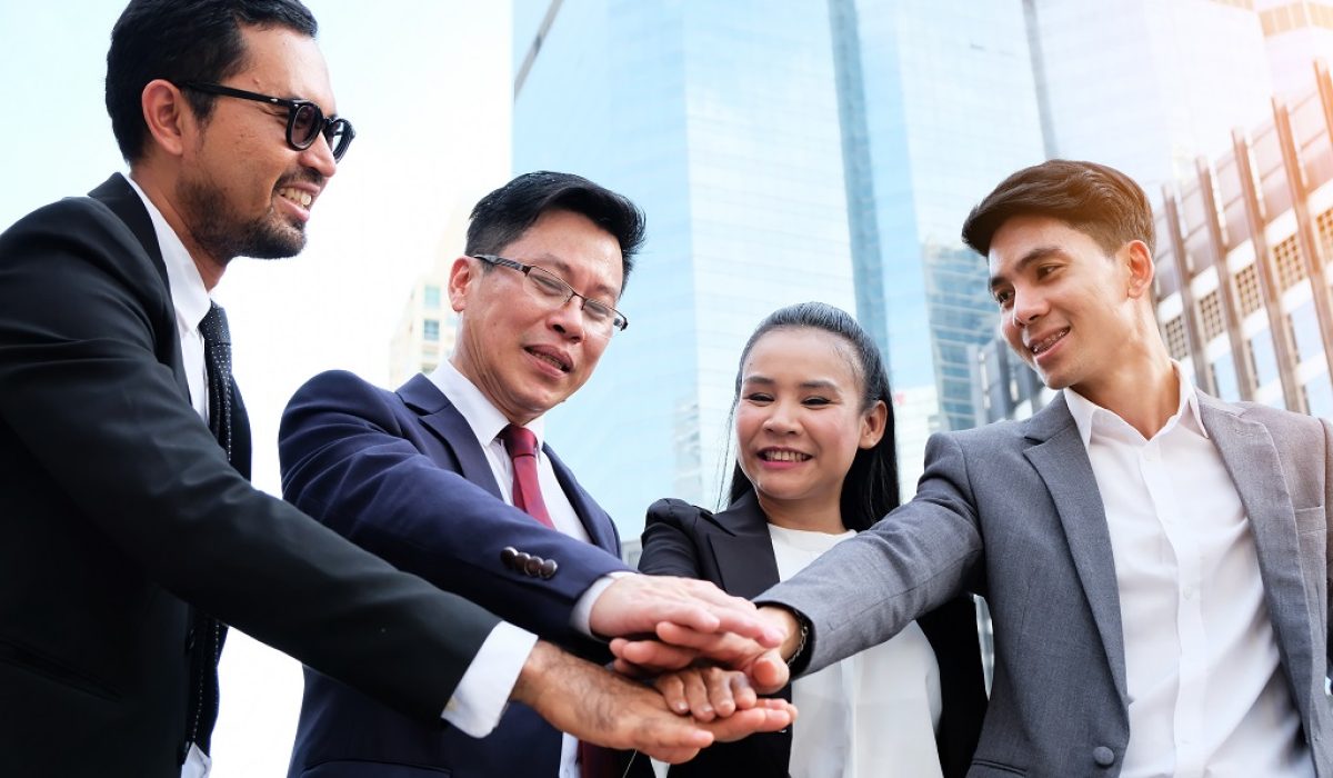 Group of business people stand congratulated.