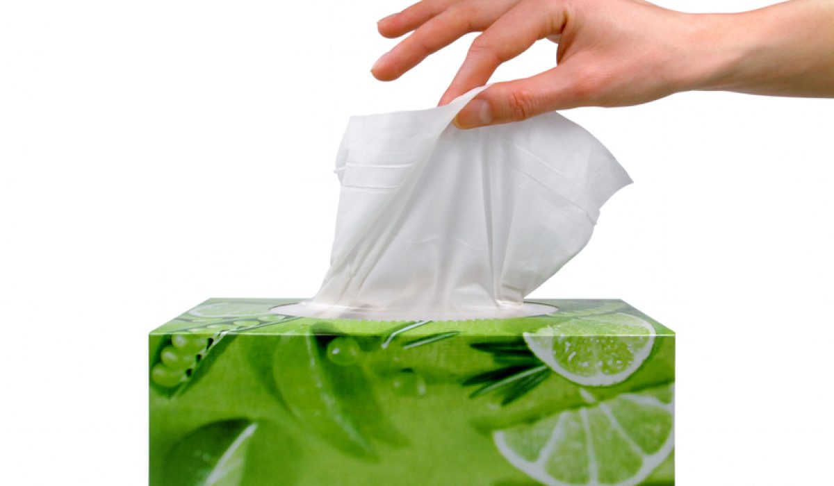 Delicate womans hand pulls a tissue from a green tissue box.