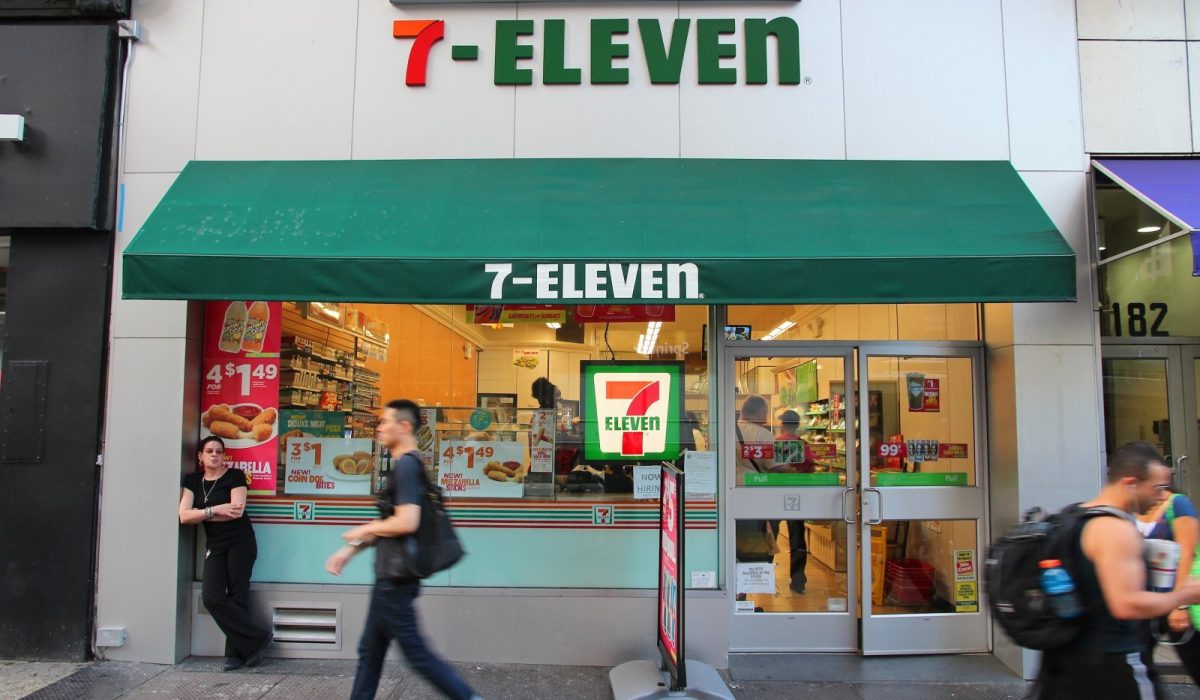 New York, United States - July 3, 2013: People walk past 7-Eleven convenience store in New York. 7-Eleven is world's largest operator, franchisor and licensor of convenience stores, with more than 46,000 shops.