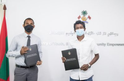 ތުރާކުނު ފުޓްބޯޅަ ދަނޑުގައި ޓާރފްއެޅުމަށް ސޮއިކުރުން. ފޮޓޯ: ޔޫތު މިނިސްޓްރީ